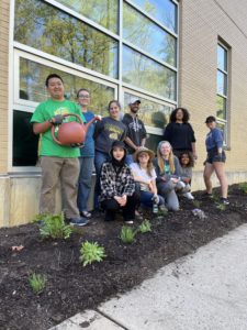 Student volunteers posing next to finished garden planting along the front of the School of Art. 