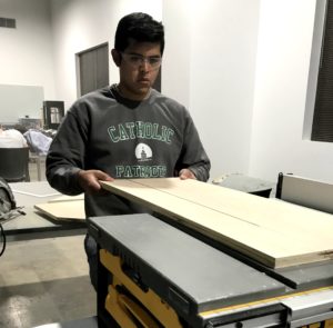 Student preparing wood to be cut on a table saw